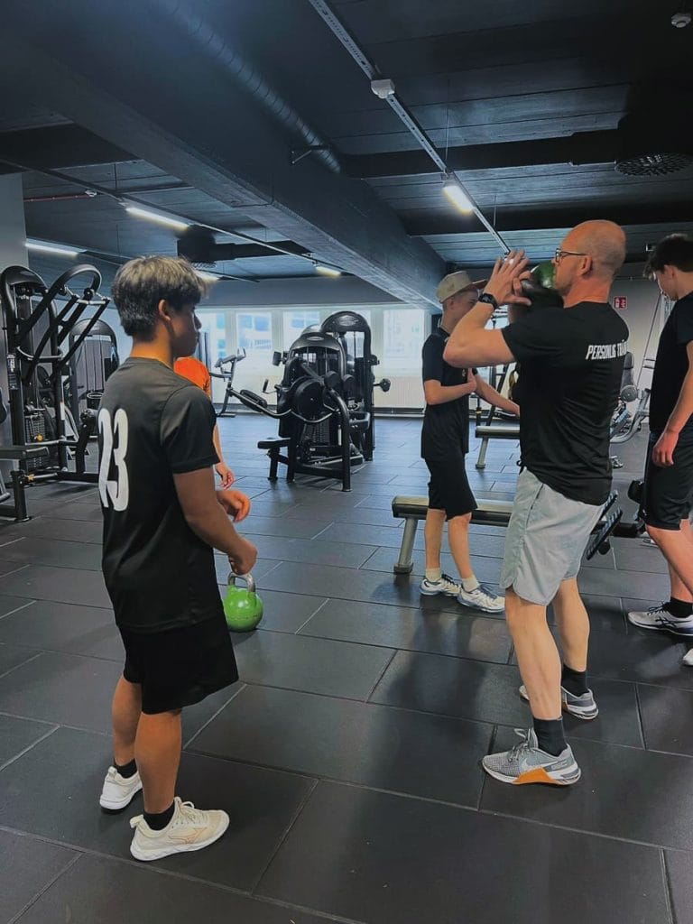 Ulf Berg coachar en klient i kettlebell-övning i gymmet – personlig träning i Örnsköldsvik